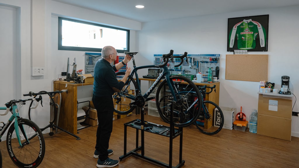 Mechanic fitting a rental bike to the rider